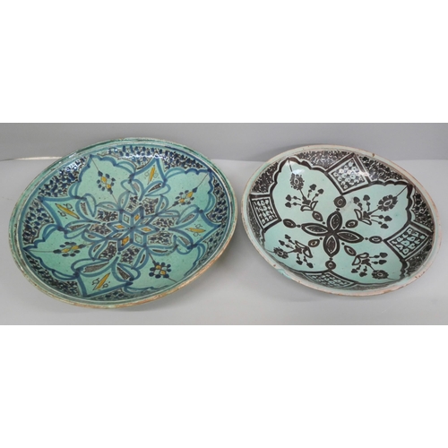 607 - Two eastern hand painted earthenware plates, possibly Moroccan, largest 24cm