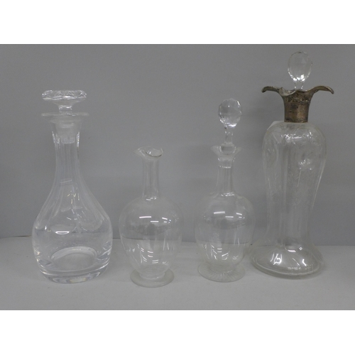 670 - A glass decanter with hallmarked silver top, top a/f and three other glass decanters, one large, two... 