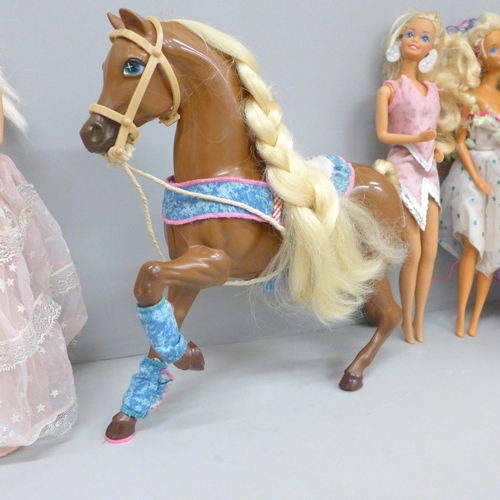 724 - A collection of eight Barbie dolls and a horse