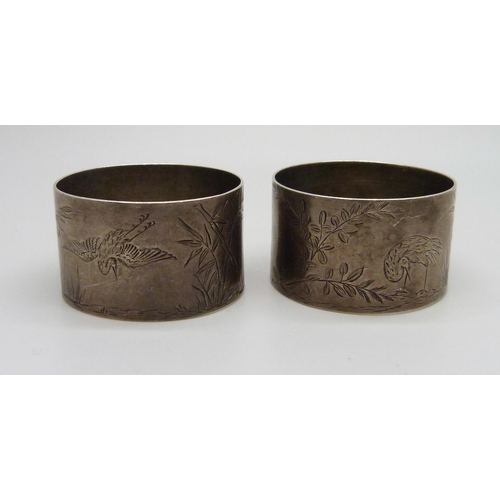 879 - A pair of Victorian silver napkin rings with bird and bamboo detail, London 1881, maker Thomas Johns... 