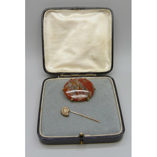 993 - A 9ct gold ammonite stick pin, 1.8g, and an agate set brooch