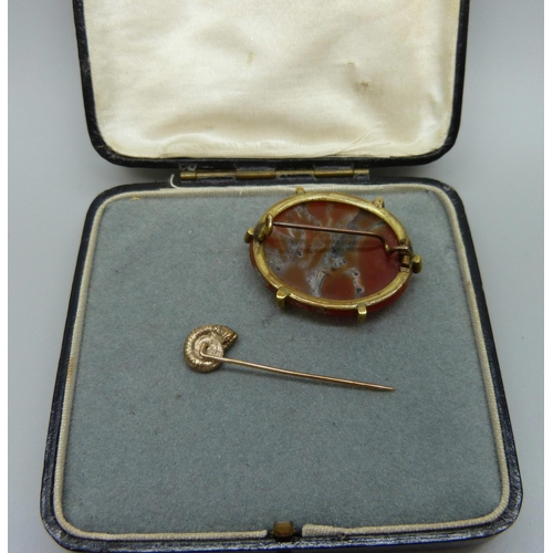 993 - A 9ct gold ammonite stick pin, 1.8g, and an agate set brooch