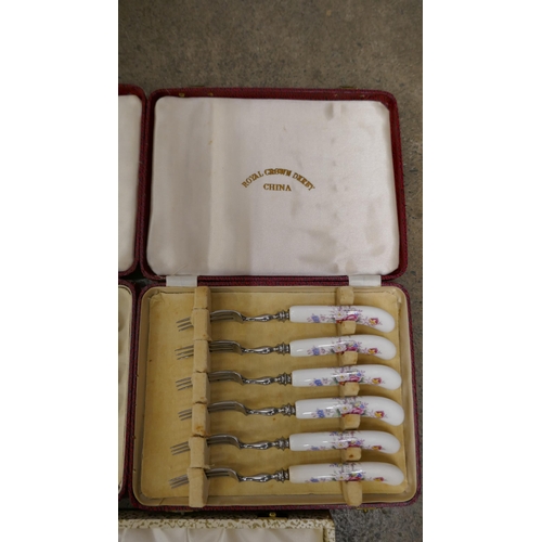 1121 - A Royal Crown Derby set of six patisserie forks in faux leather case, a Royal Crown Derby set of fou... 