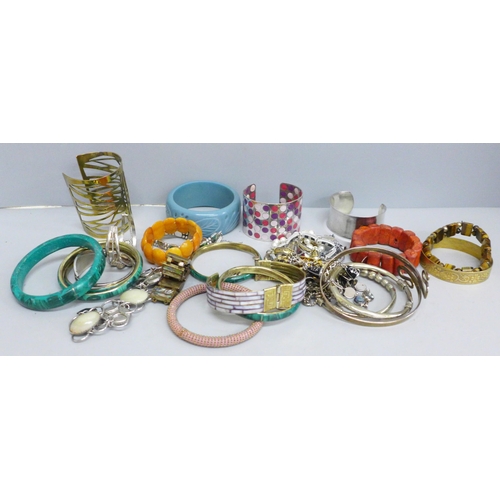 633 - A collection of bangles and bracelets including amber, coral and tiger's eye