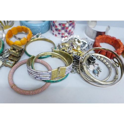 633 - A collection of bangles and bracelets including amber, coral and tiger's eye