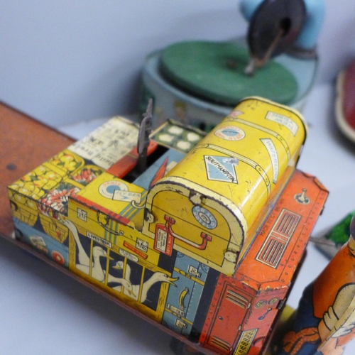 648 - Four tin-plate toys, Codeg clockwork car, clockwork luggage trolley, made in Gt. Britain, record pla... 