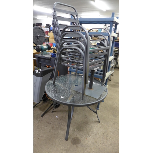 2200 - A metal and glass circular garden table with four chairs, parasole and base