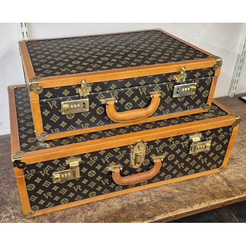 372 - Two Vr Diann coated canvas and tan leather suitcases, with gilt metal fittings and code locks