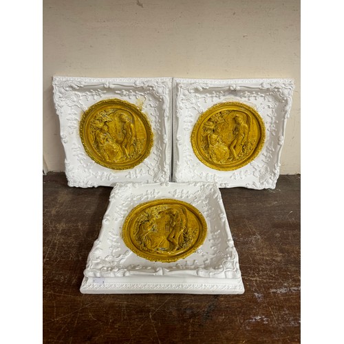 358 - A set of three high relief painted plaster plaques