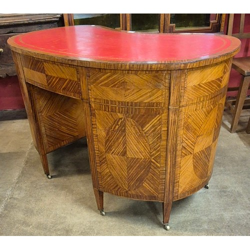 77 - A late Victorian satinwood and red leather topped kidney shaped library desk