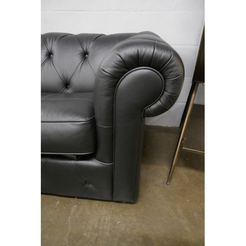 3067 - A black leather Chesterfield three seater sofa bed