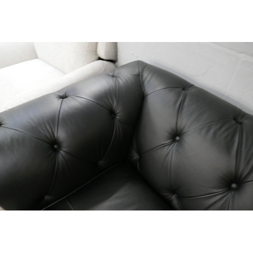 3067 - A black leather Chesterfield three seater sofa bed