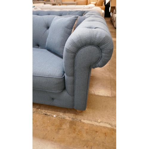 3101 - A blue upholstered Chesterfield two seater sofa and footstool