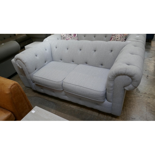 3152 - A grey upholstered Chesterfield two seater sofa and footstool