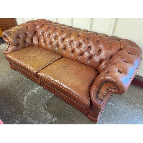 163 - A tan leather upholstered Chesterfield three seater sofa