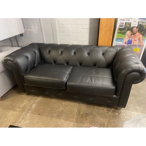 3068 - A black leather Chesterfield three seater sofa