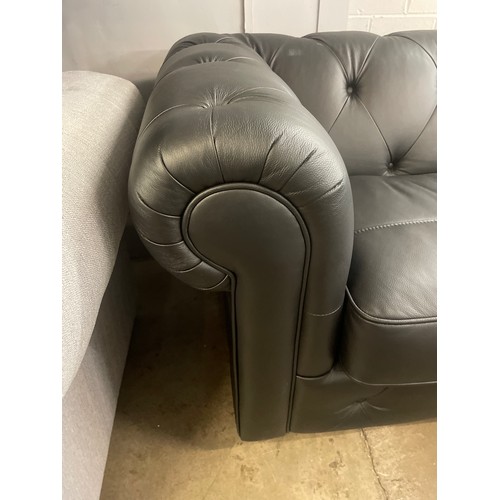 3068 - A black leather Chesterfield three seater sofa