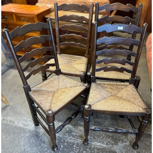 165 - A Harlequin set of four 18th Century style oak and rush seated ladderback dining chairs