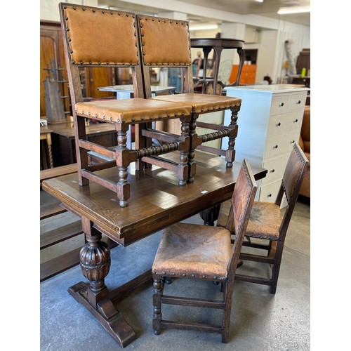 166 - An early 20th Century carved oak draw leaf table and a set of four oak and faux leather upholstered ... 