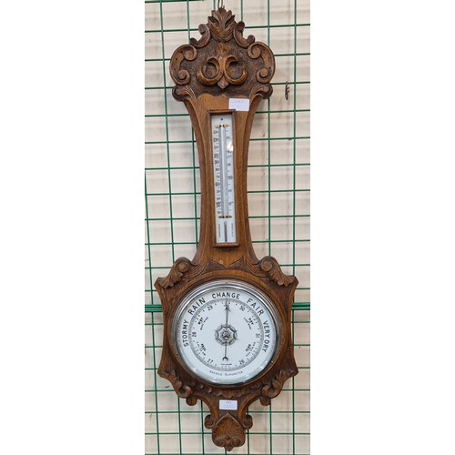 321 - An Edward VII carved oak aneroid barometer