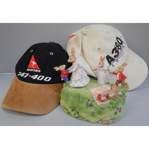 745 - A Royal Doulton Bunnykins musical box and two baseball caps, A380 and Qantas 747-400