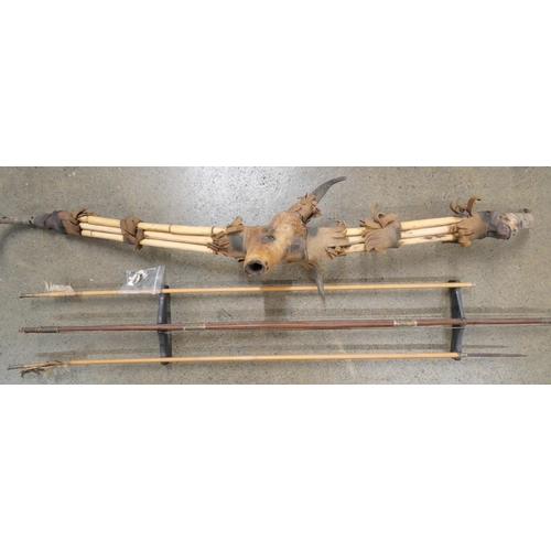 779 - A tribal bow constructed from bamboo, horn and animal skin, two arrows, etc.