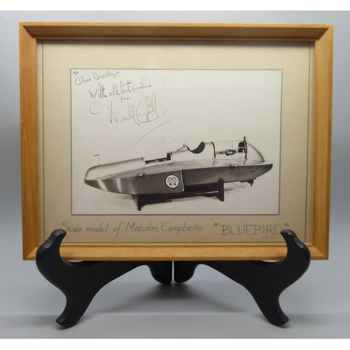 829 - A mounted photograph of a scale model of Malcolm Campbells K4 'Blue Bird', signed by Donald Campbell... 