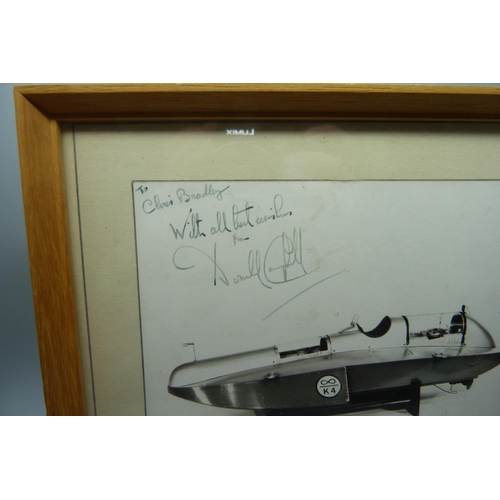 829 - A mounted photograph of a scale model of Malcolm Campbells K4 'Blue Bird', signed by Donald Campbell... 