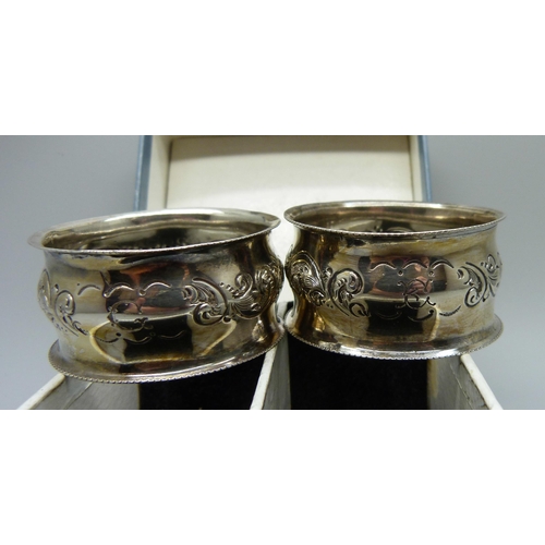 859 - A pair of silver napkin rings, boxed, embossed decoration, Birmingham 1903