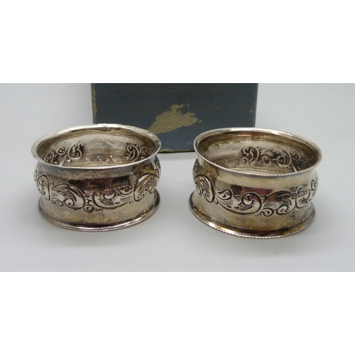 859 - A pair of silver napkin rings, boxed, embossed decoration, Birmingham 1903