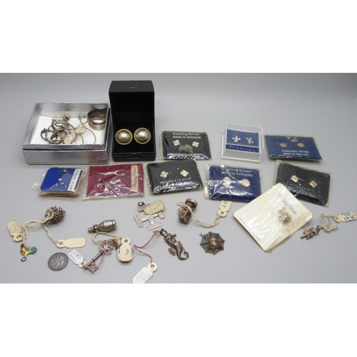 914 - A collection of silver earrings, many packaged and a collection of silver charms