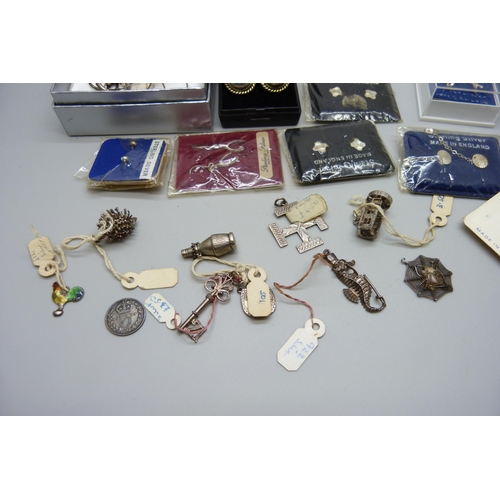 914 - A collection of silver earrings, many packaged and a collection of silver charms