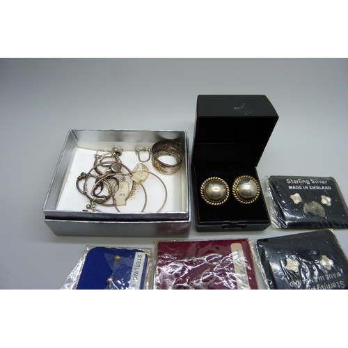 914 - A collection of silver earrings, many packaged and a collection of silver charms