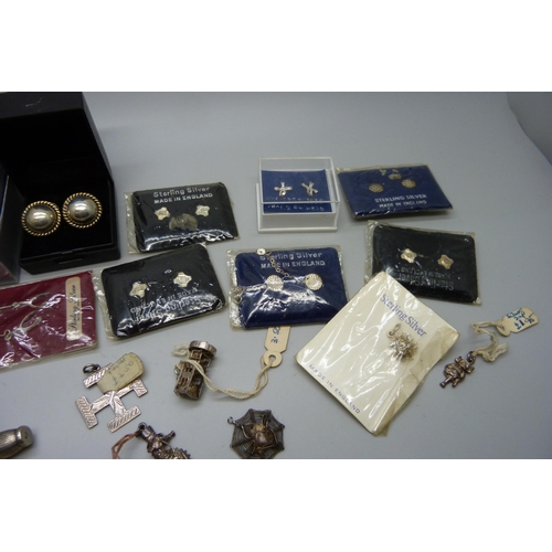 914 - A collection of silver earrings, many packaged and a collection of silver charms