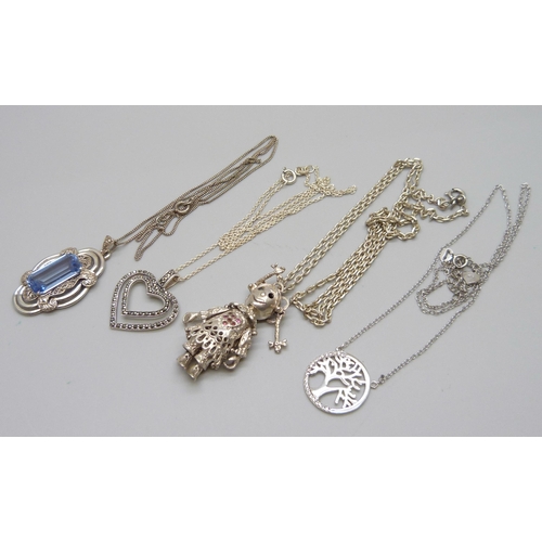 946 - Four silver pendants and chains, including an articulated rag-doll pendant, 33g