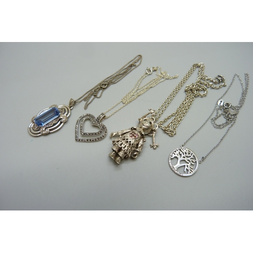 946 - Four silver pendants and chains, including an articulated rag-doll pendant, 33g