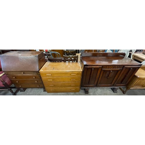 216 - A carved oak sideboard, carved oak bureau and an oak chest of drawers