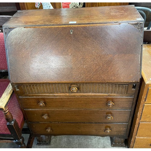 216 - A carved oak sideboard, carved oak bureau and an oak chest of drawers