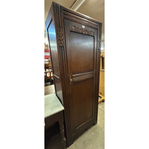 236 - An early 20th century carved oak wardrobe