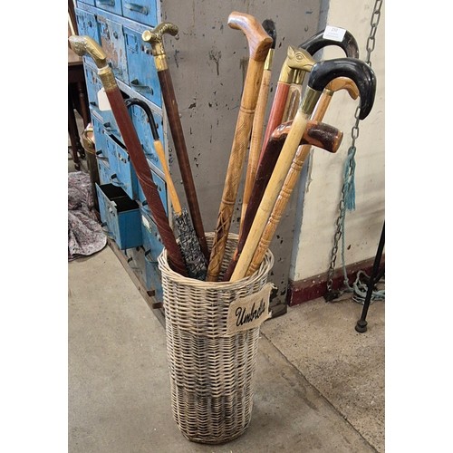 250 - A collection of walking sticks and a wicker umbrella stand