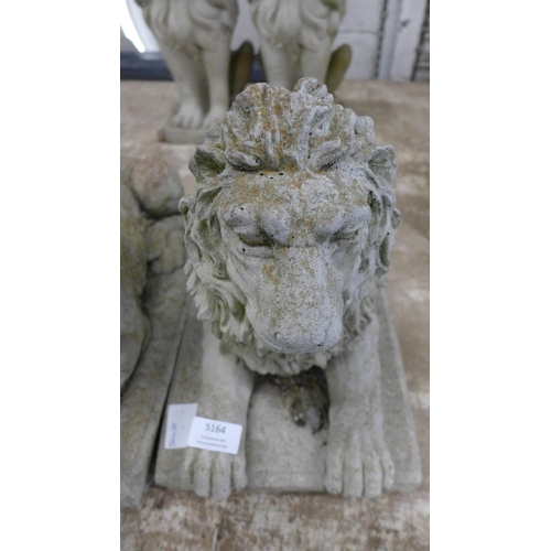 5164 - A pair of concrete stone effect laying lion garden ornaments