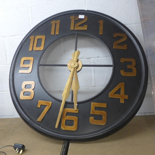 5047 - A large black and bronze coloured metal wall clock