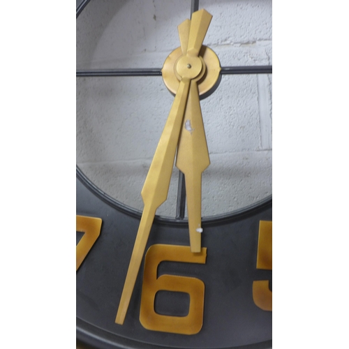 5047 - A large black and bronze coloured metal wall clock