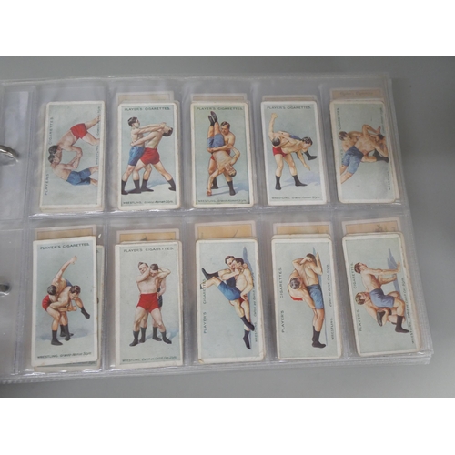 649 - Cigarette cards; an album of cigarette cards containing ten complete sets including Players 'Wrestli... 