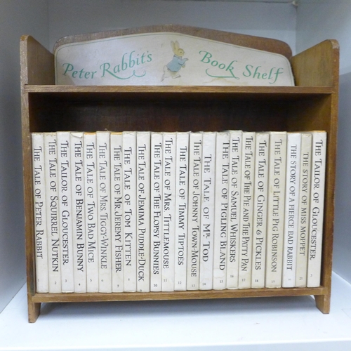 748 - A set of 21 Beatrix Potter Peter Rabbit books with book shelf