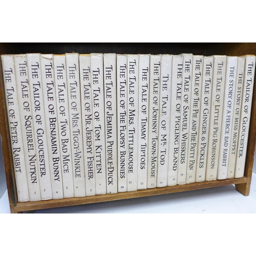 748 - A set of 21 Beatrix Potter Peter Rabbit books with book shelf