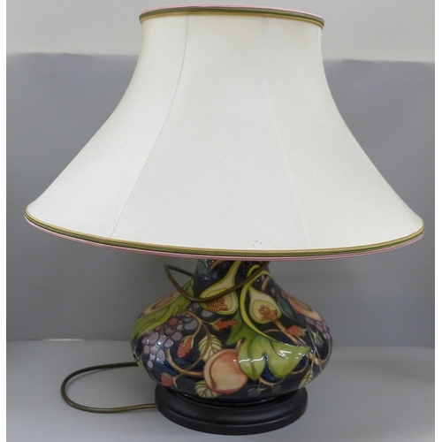 788 - A Moorcroft tube lined table lamp base, decorated with peach, grape and figs, with shade