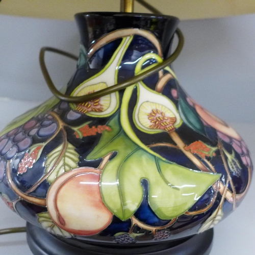 788 - A Moorcroft tube lined table lamp base, decorated with peach, grape and figs, with shade