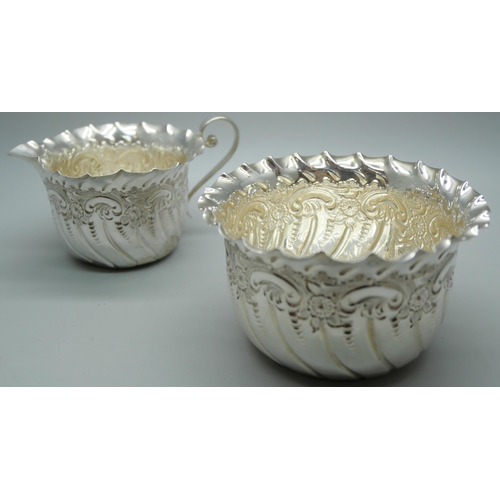 841 - An embossed silver cream jug and sugar bowl, Sheffield 1889, 95g