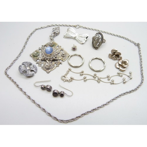 883 - A large stone set cross pendant, a silver cross brooch, a silver ring, etc.